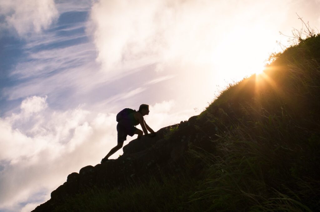 young man climbing up a steep hill